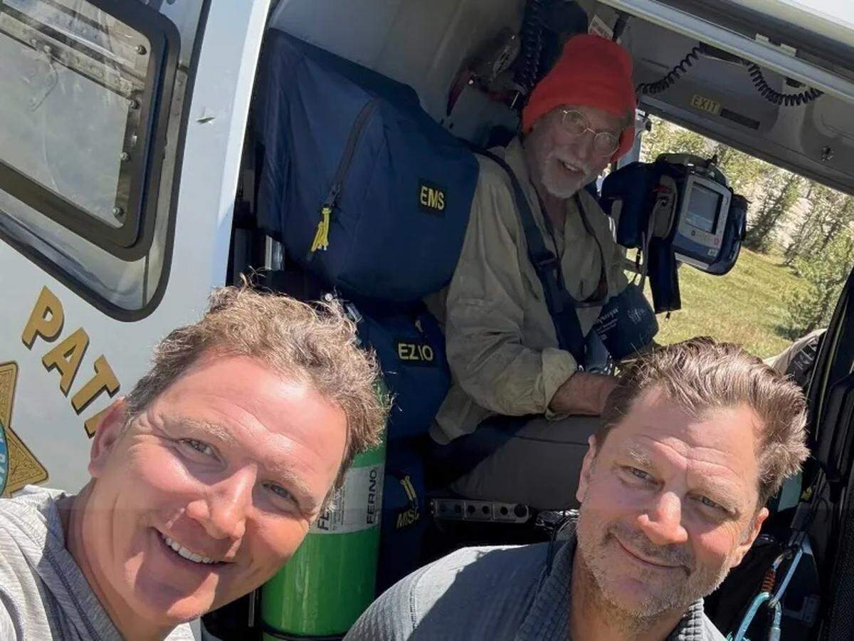Santa Barbara Boy Scout leaders Michael-James Hey, left, and Orin Rowe take a photo with Douglas Montgomery, in the red hat, after helping him board a rescue helicopter in the Emigrant Wilderness.