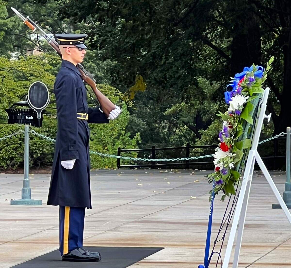 A sentinel stands near a wreath during a ceremonial visit at Arlington National Cemetery during an Honor Flight Central Coast California trip to Washington, D.C.