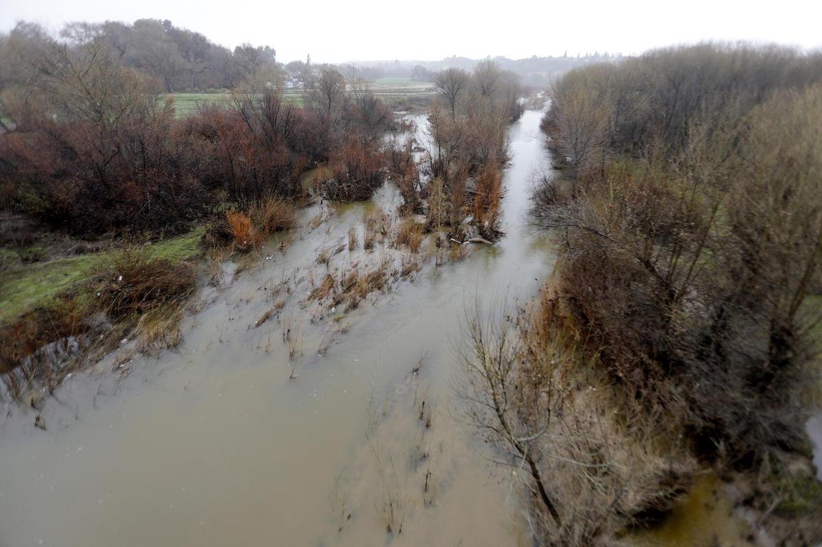 The Salinas River is flowing quietly under the Niblick Bridge in Paso Robles before the approaching bomb cyclone storm.