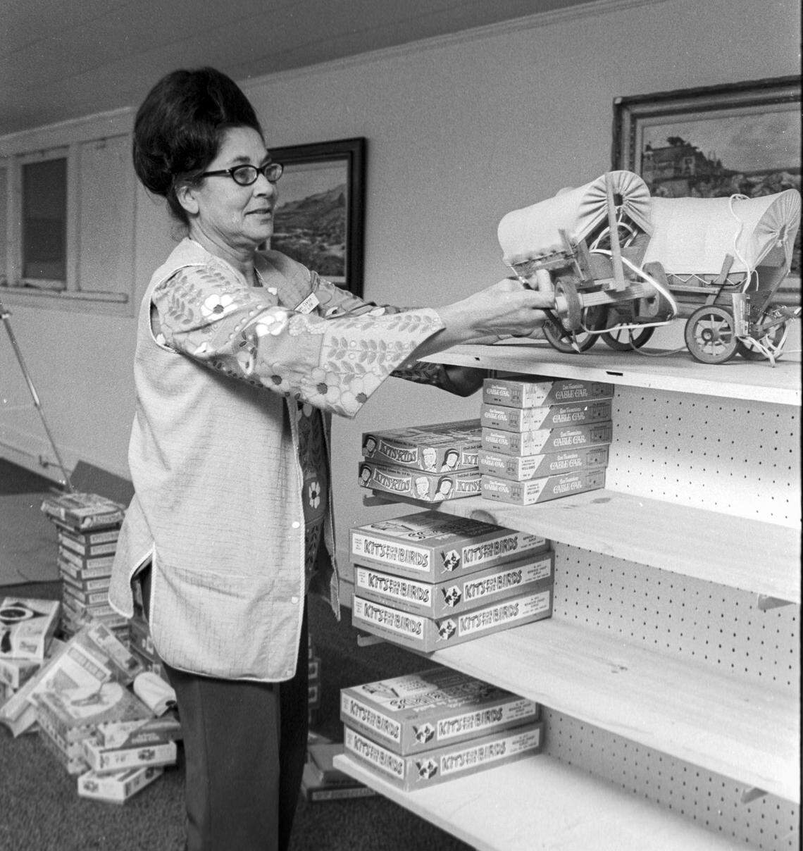 Mrs. Beth Law, owner of Law's Hobby Shop, stocks the shelves at new quarters in the Masonic Temple building on Oct. 20, 1971. This was the third location for the growing business.