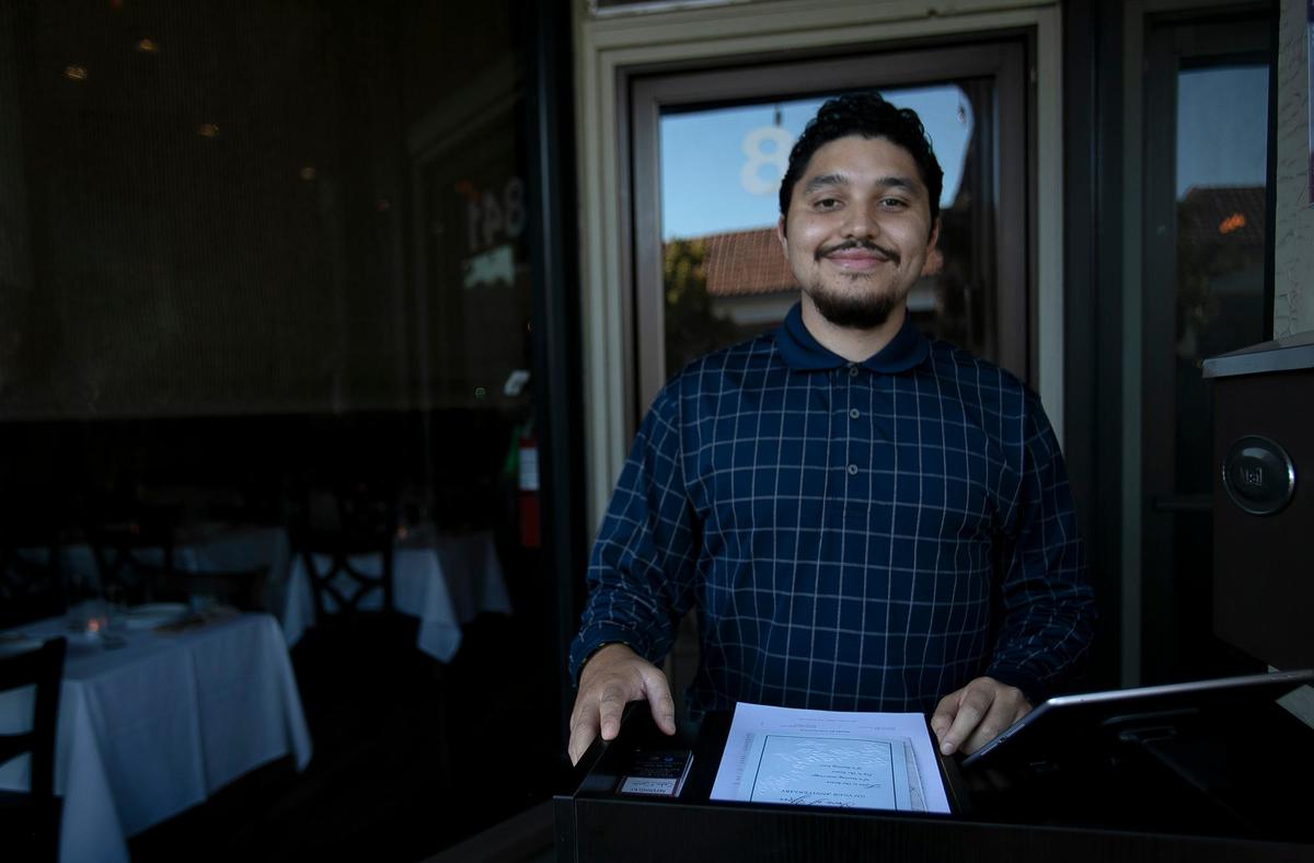 Foods from Honduras, Italy, Spain and other countries shape the menu of the new Sabor & Sazon restaurant in Paso Robles. Floor manager Junior Magdonal mans the host desk in front of the restaurant.