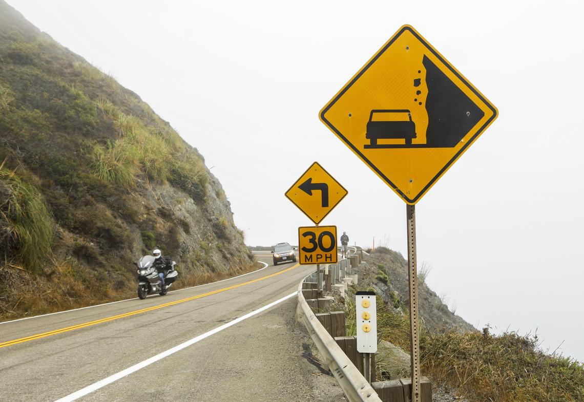 Vehicles drive around a corner on Highway 1 earlier this year near the newly opened section across the Mud Creek Slide. Work at the Paul’s Slide site farther north will bring overnight closures to the highway next week.