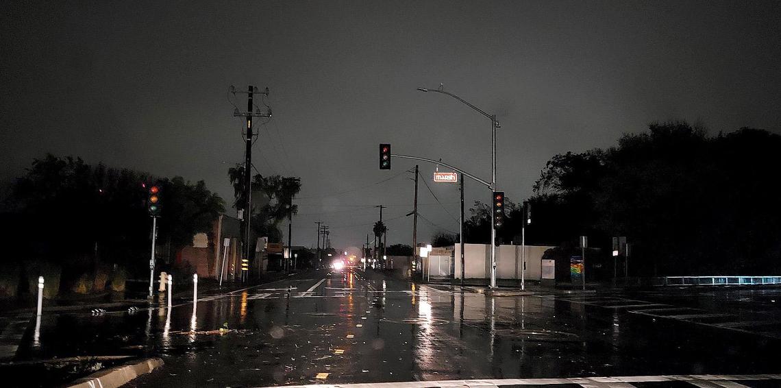 Vehicle headlights illuminate the black signal lights on S. Higuera Street and Marsh Street intersection.