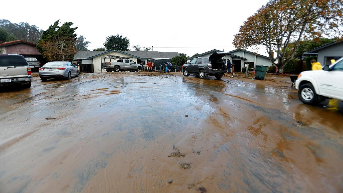 The residents of Vista Court in Los Osos clean up after their neighborhood on Tuesday, Jan. 10, one day after a flood of mud and water inundated several homes.