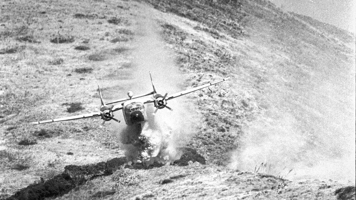 CDF plane makes drop of fire retardant Aug. 1, 1983 in spectacular precision sweep down burning hillside above campus of ol San Luis Obispo Junior High.
