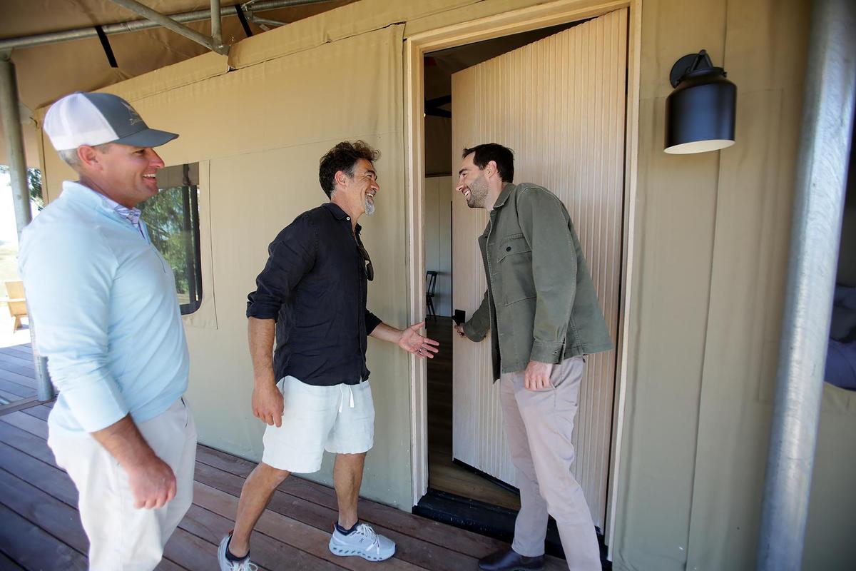 Nightsky camps will build 45 eco tents on the Dairy Creek Golf Course by spring of 2026, repurposing nine unused holes for a sustainable, luxury getaway. David Smith, CEO of and partner at Nightsky camps, right, demonstrates going into the tent’s front door, with Anatoly Mezhov, development manager and partner at Nightsky, center, and Josh Heptig, SLO County parks golf superintendent on the left.