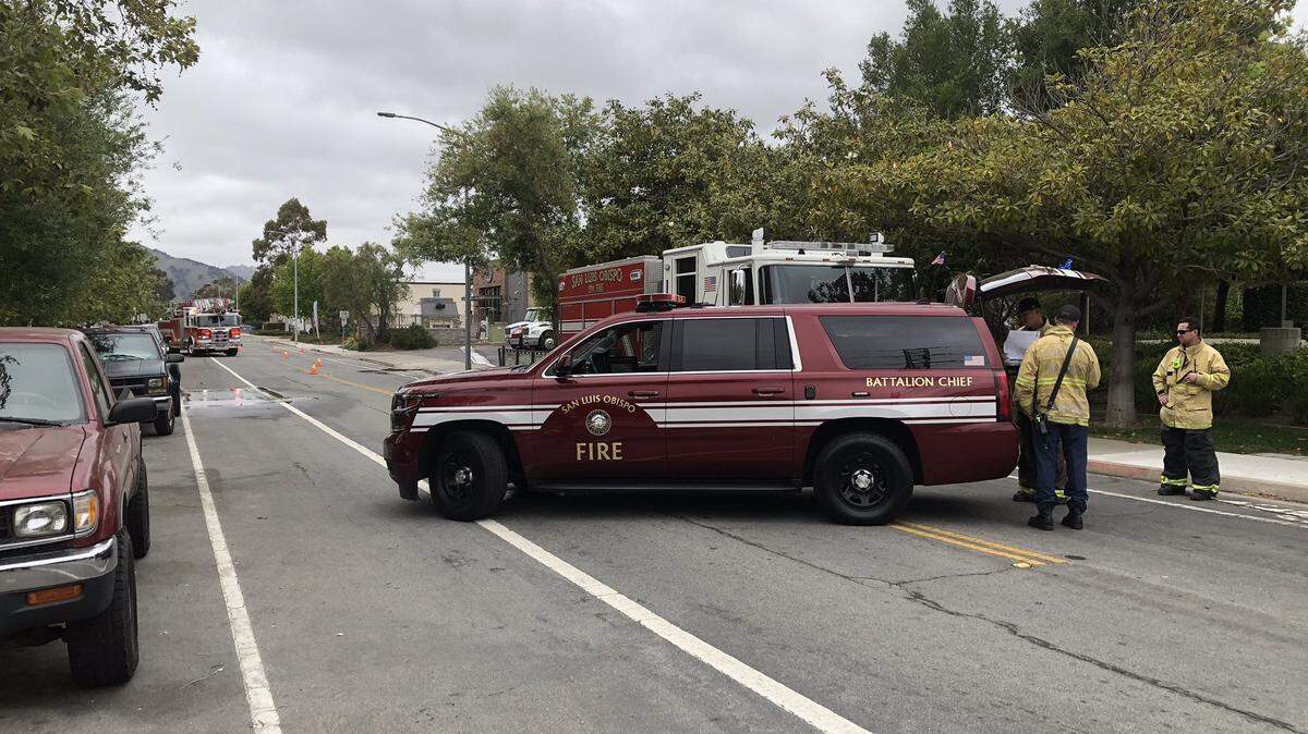 Crews from the San Luis Obispo City Fire Department worked to block off Sacramento Drive on Sunday afternoon after about 2,000 gallons of sewage leaked onto the street and into a dry creekbed.