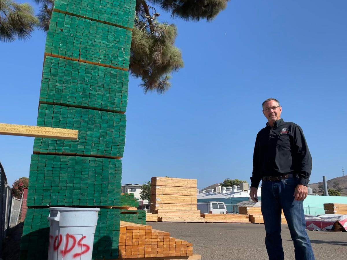 Hayward Lumber regional manager Rudy Lockhart stands with a stack of lumber in the lumber yard at Hayward’s San Luis Obispo facility.
