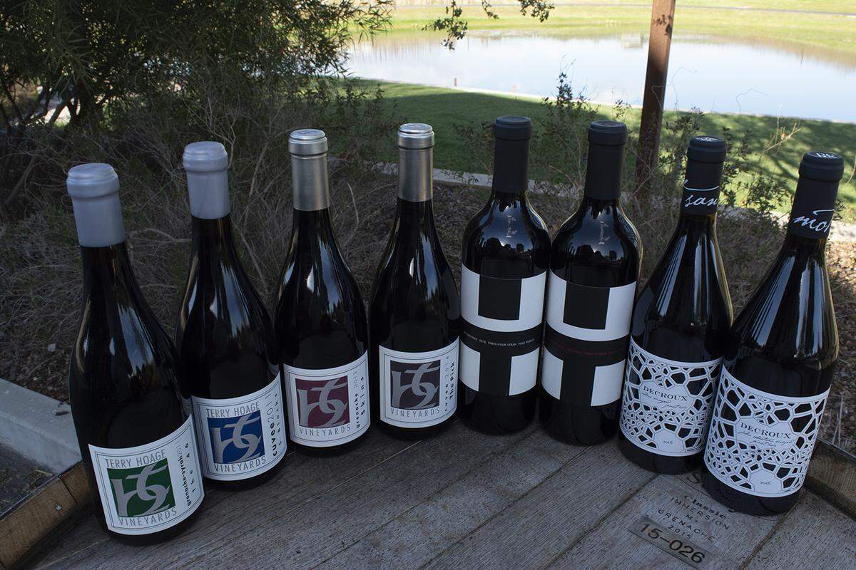 A collection of TH Estate Wines, with a grassy backdrop.