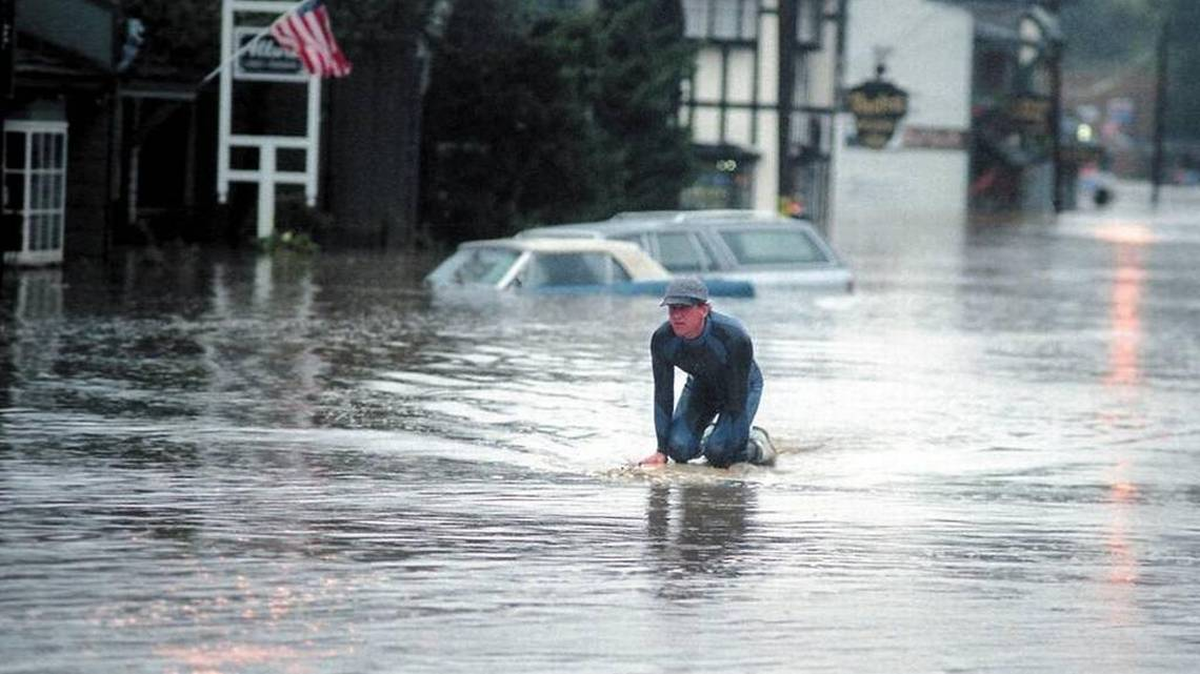 A surfboard was the preferred vehicle for getting around Main Street in the West Village of Cambria on March 10, 1995, when heavy rains and high tides combined to flood the town with the waters of Santa Rosa Creek.