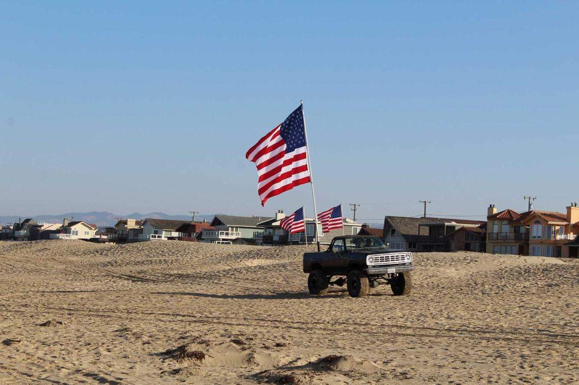 A truck adorned with American flags drives along the beach at the Oceano Dunes State Vehicular Recreation Area on Friday as the park reopened to vehicles for the first time in seven months.