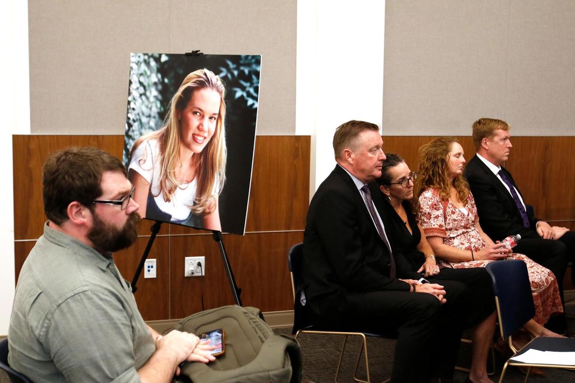 Chris Lambert sits in front of a poster of Kristin Smart with family members nearby. Hours after a jury found Paul Flores guilty of the 1996 murder of Cal Poly student Kristin Smart, San Luis Obispo County officials gathered to share their reactions to the conviction.