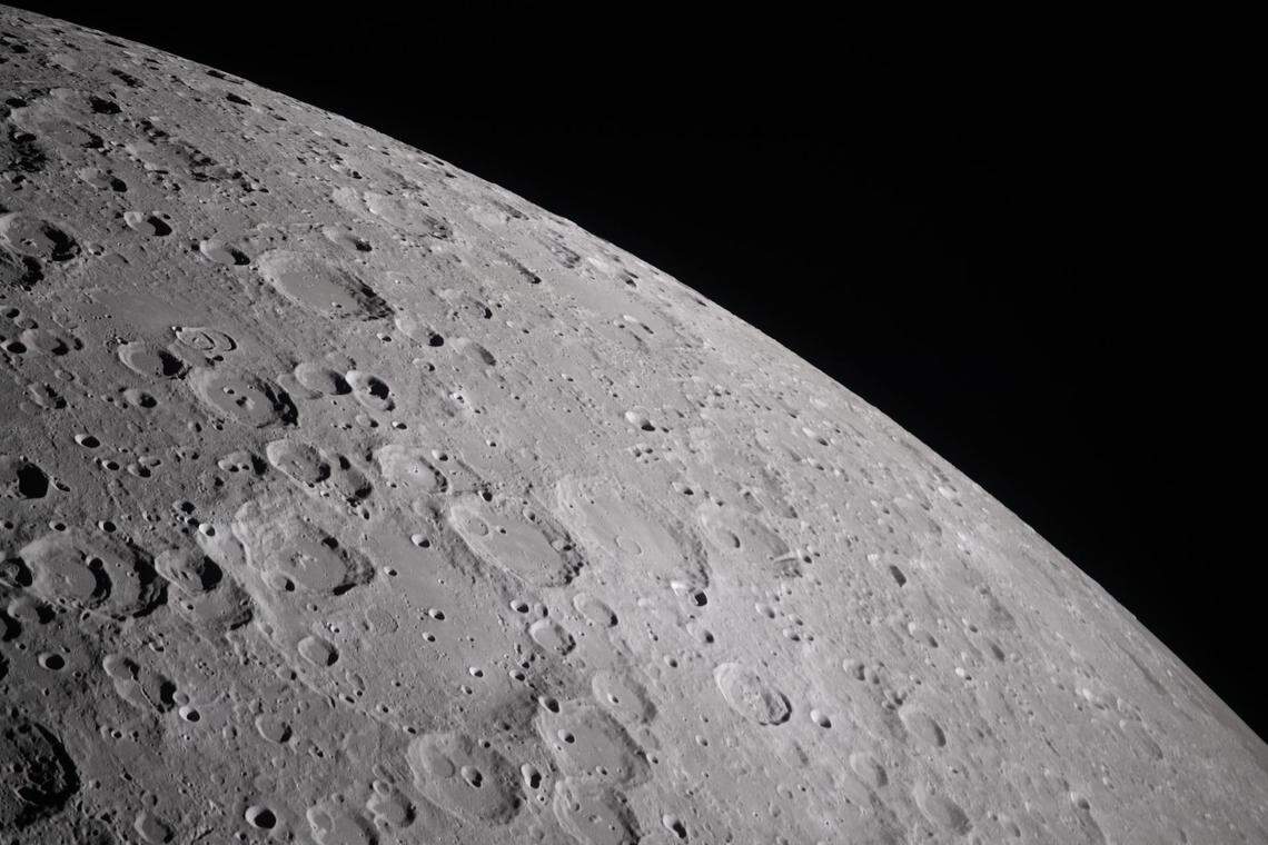 During the lunar flyby observation period on April 6, 2026, the Artemis II crew captures craters dotting the surface of the moon, revealing its rugged, ancient surface. This scarred landscape reflects a long history of cosmic collisions.