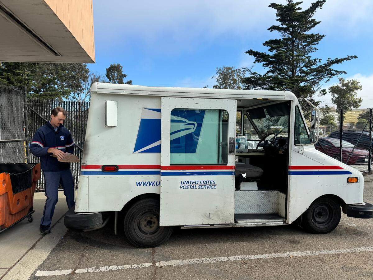 U.S. Postal Service Letter Carrier Zach Sherer loads more than a 100 packages into his vehicle on Dec. 4, 2024.