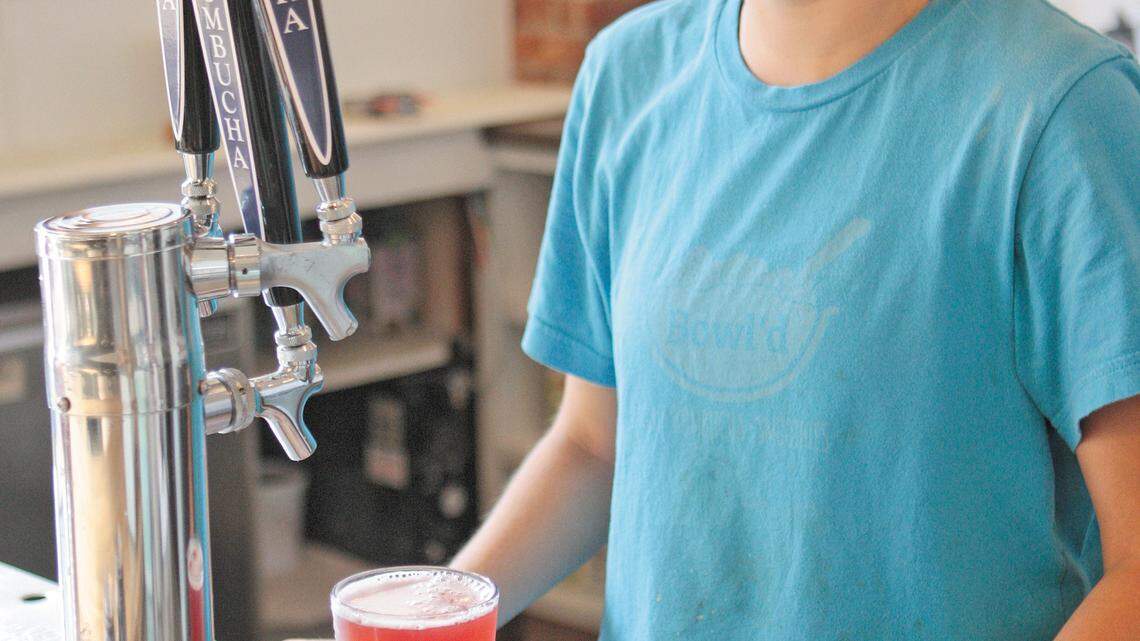 Bowl’d server Megan Mossman pours some Whalebird kombucha from a tap.