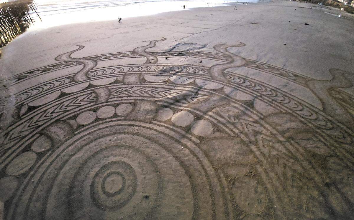 The Pismo Beach Sand Art Festival runs Nov. 6 to Nov. 8 as artists carve sand murals at low tide; view zones from SeaCrest, Wilmar Avenue, the pier or hotel rooftops. This sand art north of Pismo Pier was created by Manuel Frolich who lives in Ireland.