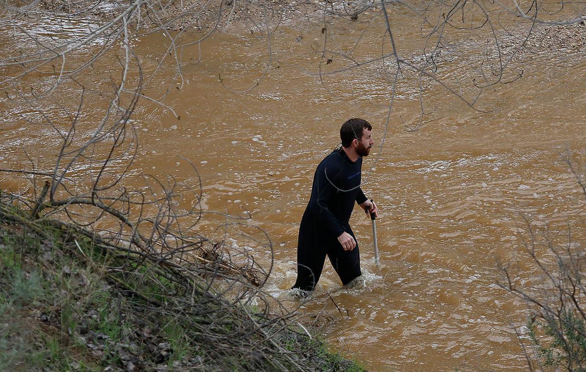 Searchers check through floodwaters for any sign of 5-year-old Kyle Doan on Wednesday, Jan. 11, 2023, two days after he disappeared in swollen San Marcos Creek near San Miguel.