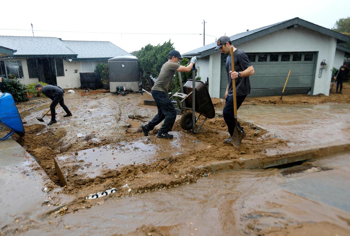 Los Osos residents turned out Tuesday, Jan. 10, 2023, to help clean up mud and debris that hit homes on Vista Court when a water retention basin failed and sent a torrent of floodwater pouring down onto the neighborhood from the hillside above.