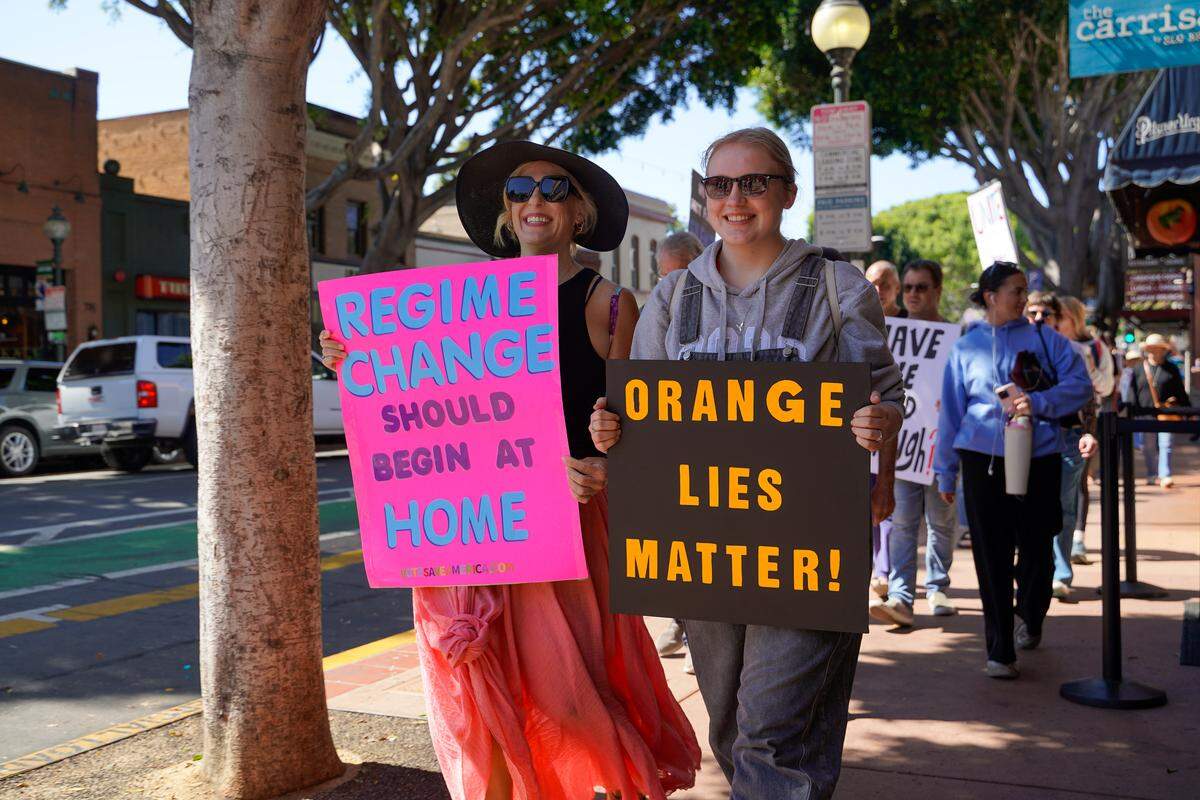 Los Osos mother and daughter duo Molly and Bridget O'Leary march during the No Kings protest in San Luis Obispo on Saturday, March 28, 2026. Organizers estimated around 2,500 people attended the San Luis Obispo protest, with more in Atascadero, Cambria and Grover Beach.
