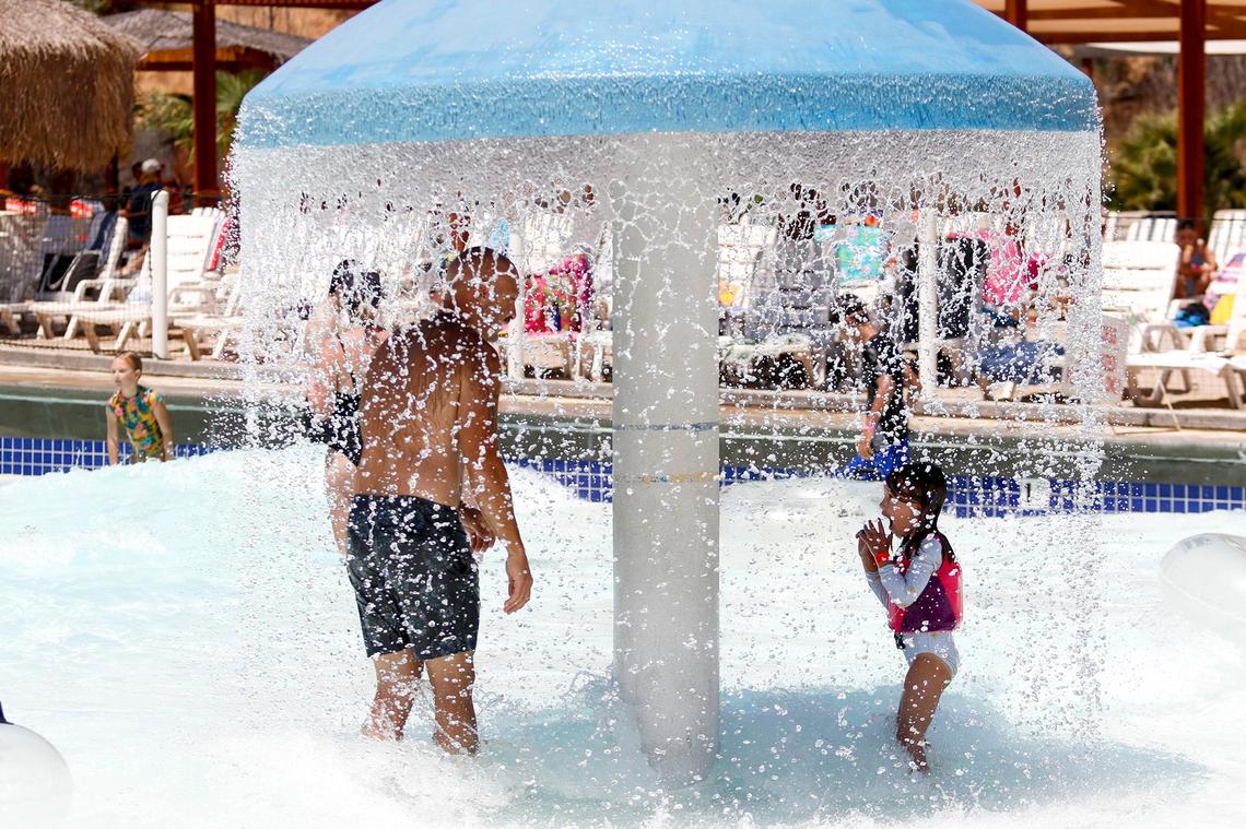 Patrick Maloney and daughter Henly Maloney, 5, of Solvang cool off in the Calypso Bay Wave Pool at The Ravine Water Park in Paso Robles as temperatures hit the triple-digits on Thursday, July 27, 2023.