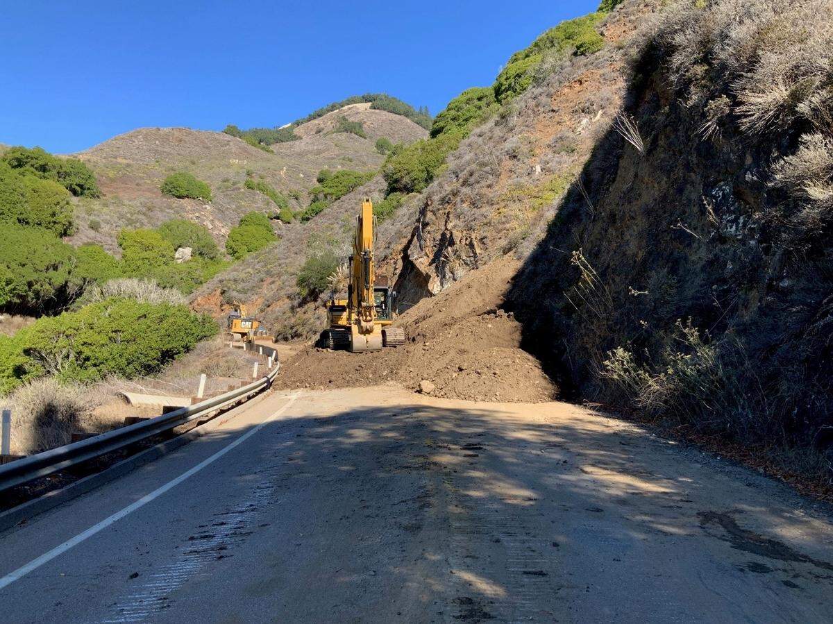 An excavator helps create a dirt ramp up to a large rock outcropping on Highway 1 on Thursday, Oct. 28, 2021. The highway will remain closed through Wednesday between Ragged Point and Gorda.