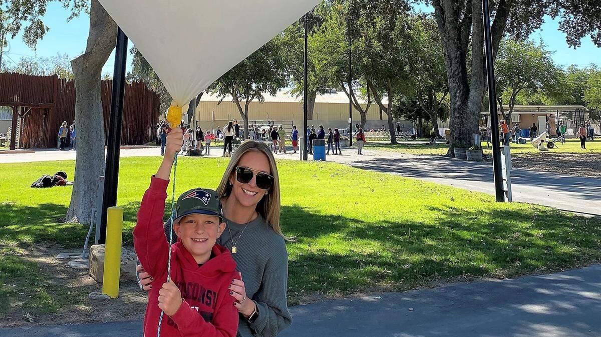 Mason and Denise Lorenzo of Atascadero hold up a weather balloon at The Great AGventure event in Paso Robles on Oct. 12, 2021.