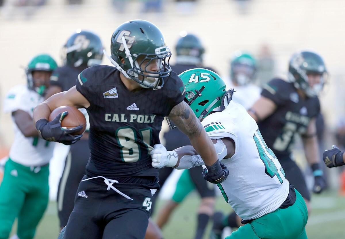 Cal Poly’s Quentin Harrison (81) fends off a tackle from North Dakota’s Cam Hunt (45) on Saturday in a Big Sky Conference game at Alex P. Spanos Stadium in San Luis Obispo.