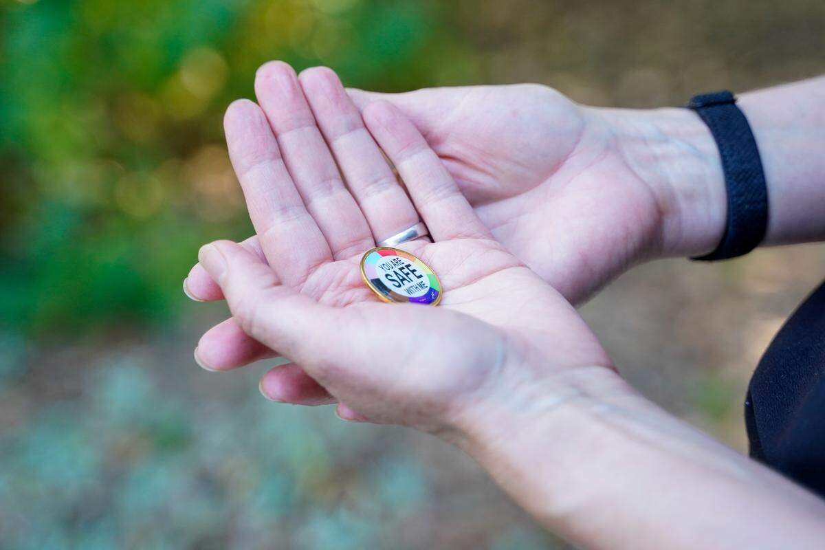 A button worn by Atascadero Middle School student Selby sits in the hands of their mother Darcy, pictured here Monday, June 30, 2025. Selby uses they/them pronouns and is a member of the LGBTQ+ community, founding their middle school’s Gay Straight Alliance.