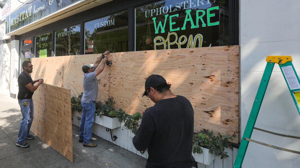 Workmen board up the windows on Habitat on Marsh Street.