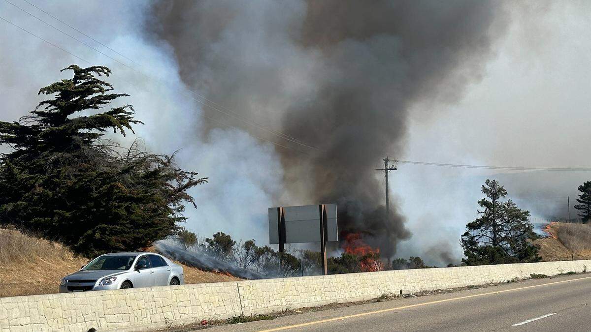 A vegetation fire burns along Highway 1 near South Bay Boulevard in Morro Bay around noon on Nov. 1, 2023.