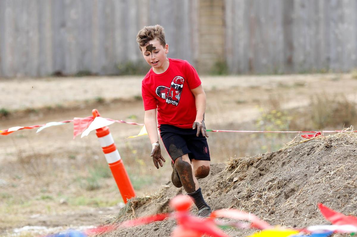 Oliver Panofsky, 7, of Arroyo Grande runs the obstacle course at the Laguna Lake September Scramble with a splotch of mud on his forehead and mud all over his legs. The sixth annual event was held at the Laguna Lake Golf Course in San Luis Obispo on Saturday, Sept. 30, 2023.