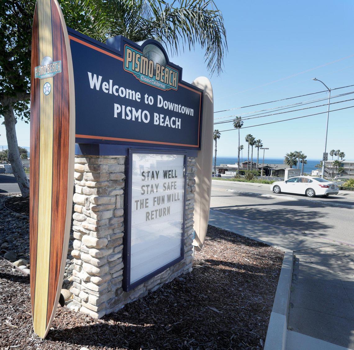 The sign at the entry to downtown Pismo Beach reads “Stay well. Stay Safe. The fun will return.”