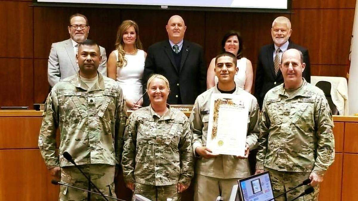 Lt. Col. Francisco Flores, front left, and Chief Warrant Officer Simone Y. Hosey, second from left front, pose for a photo at the Board of Supervisors in July 2018 during a celebrating the program’s 20th anniversary. Hosey has filed a lawsuit accusing Flores of sexual harassment.