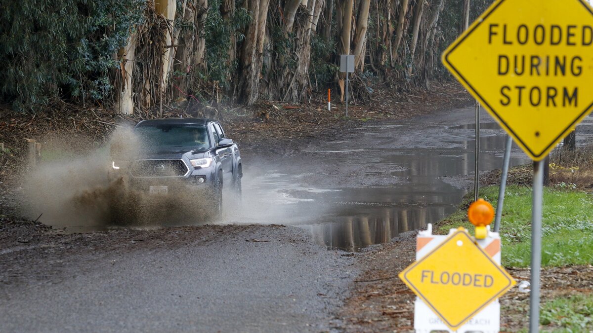 A truck runs through water on 4th Street between Grover Beach and Oceano on Tuesday.