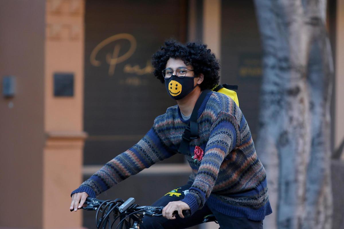 A cyclist rides down Morro Street in downtown San Luis Obispo on Thursday in a week that saw the county slip back into the more restrictive purple tier and the state enact a curfew.