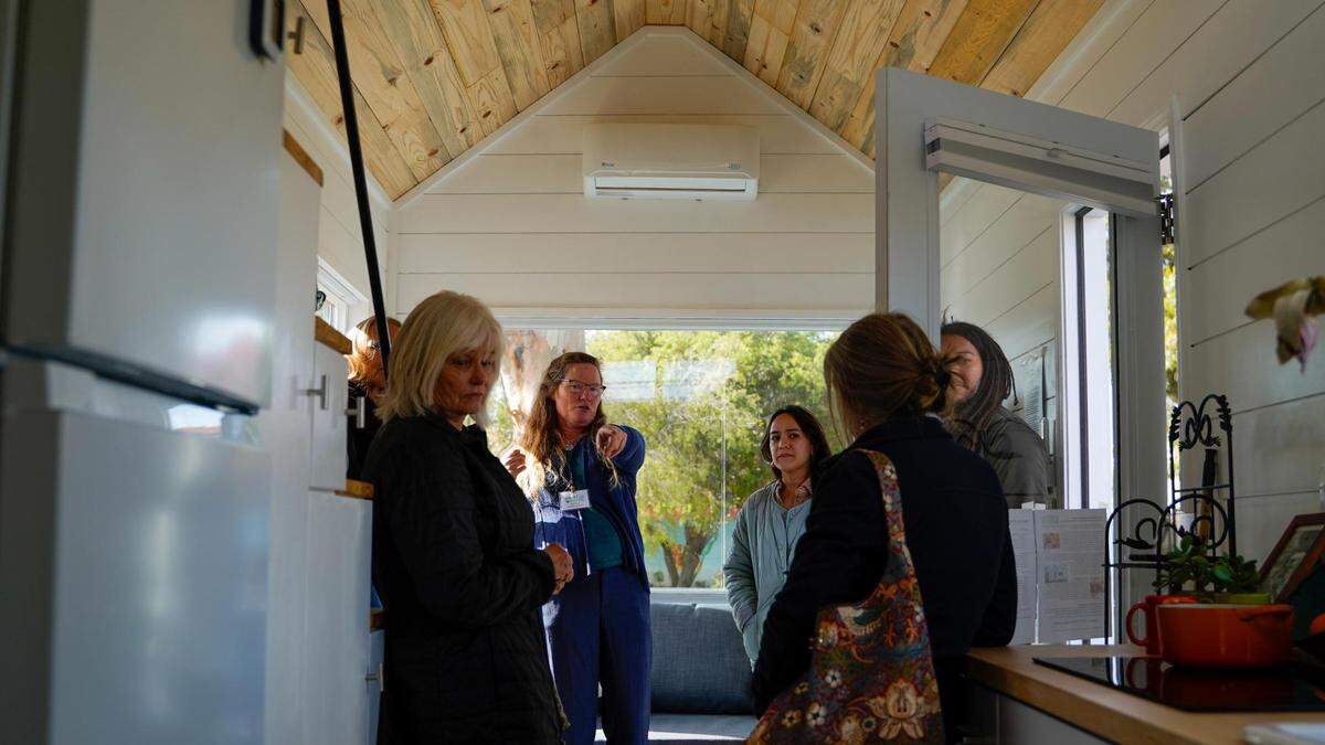 Anne Wyatt, executive director of Smart Share Housing Solutions, points to an electric appliance in the model tiny home at the Waterman Village project, which would would turn Rosa Burton de Canet Adobe, a historic property on Dana Street near the San Luis Obispo Children’s Museum, into 20 units of affordable tiny homes.