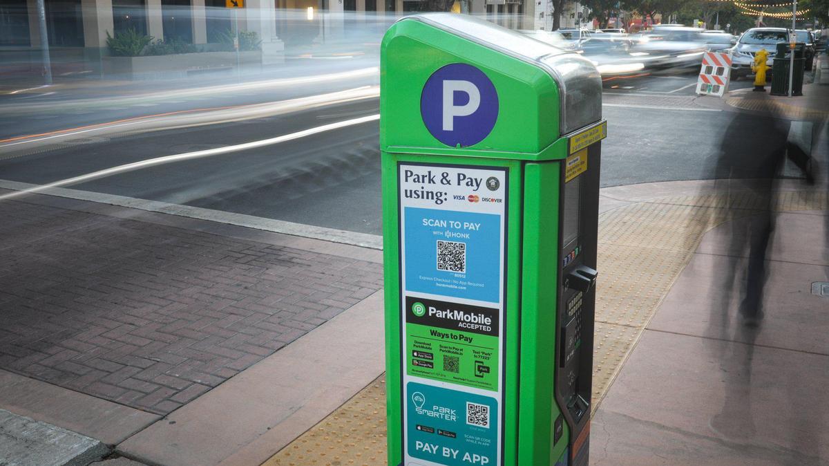 Traffic streams by one of San Luis Obispo’s parking kiosks, which have replaced parking meters in the downtown core. Parking fees are now paid via app or credit card.
