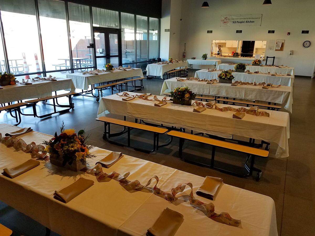 Tables in the 40 Prado Homeless Shelter dining hall are decorated with a Thanksgiving spread by the People’s Kitchen of San Luis Obispo in 2021. The volunteer organization serves clients at 40 Prado 364 days a year. The only exception is Christmas Day.