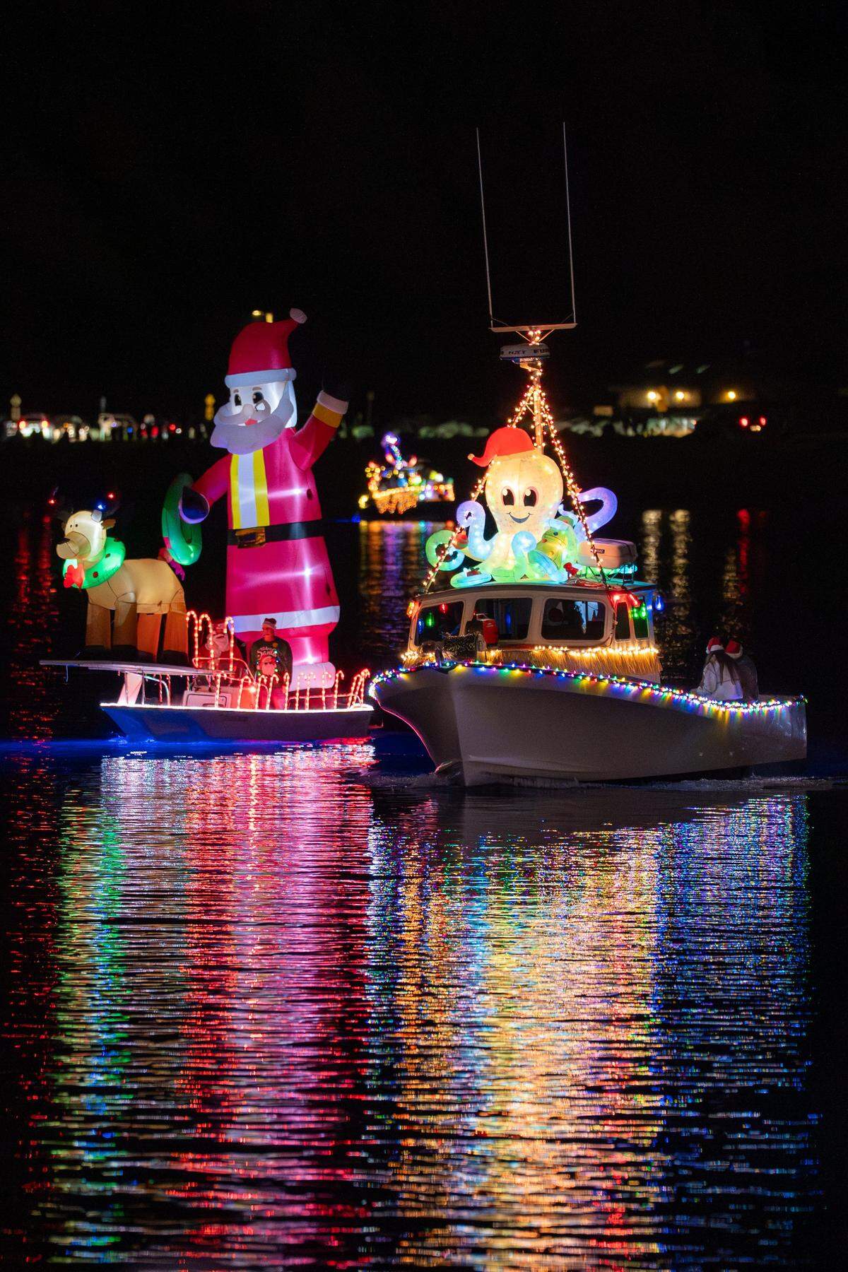 A pair of small boats equipped with inflatable Christmas decorations arrive in the Morro Bay Lighted Boat Parade on Saturday, Dec. 13, 2025. The parade drew thousands of onlookers and dozens of boats equipped with festive lighting.