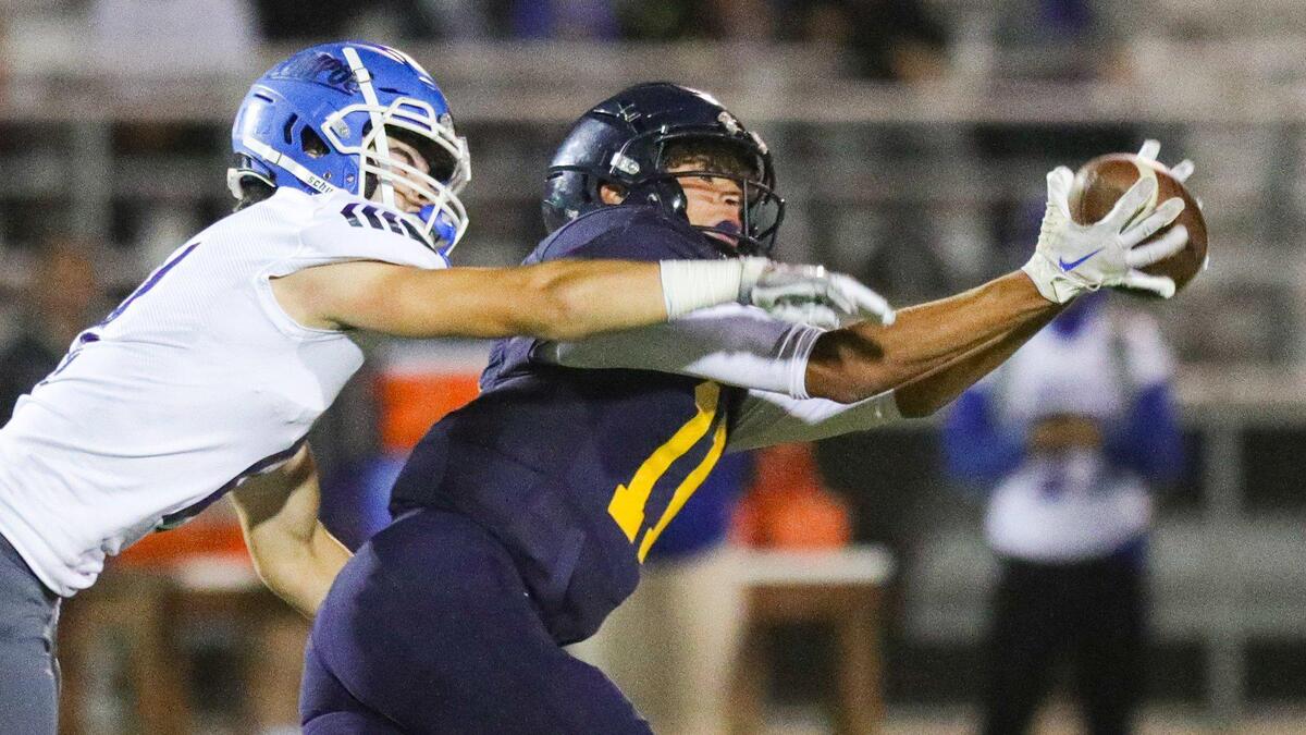 Damien Santos of the Eagles stretches for a catch at the end of the first half while being defended by Monte Ortiz. Arroyo Grande fell to Lompoc 42-37 in a hard-fought Mountain League football opener on Sept. 16, 2022.