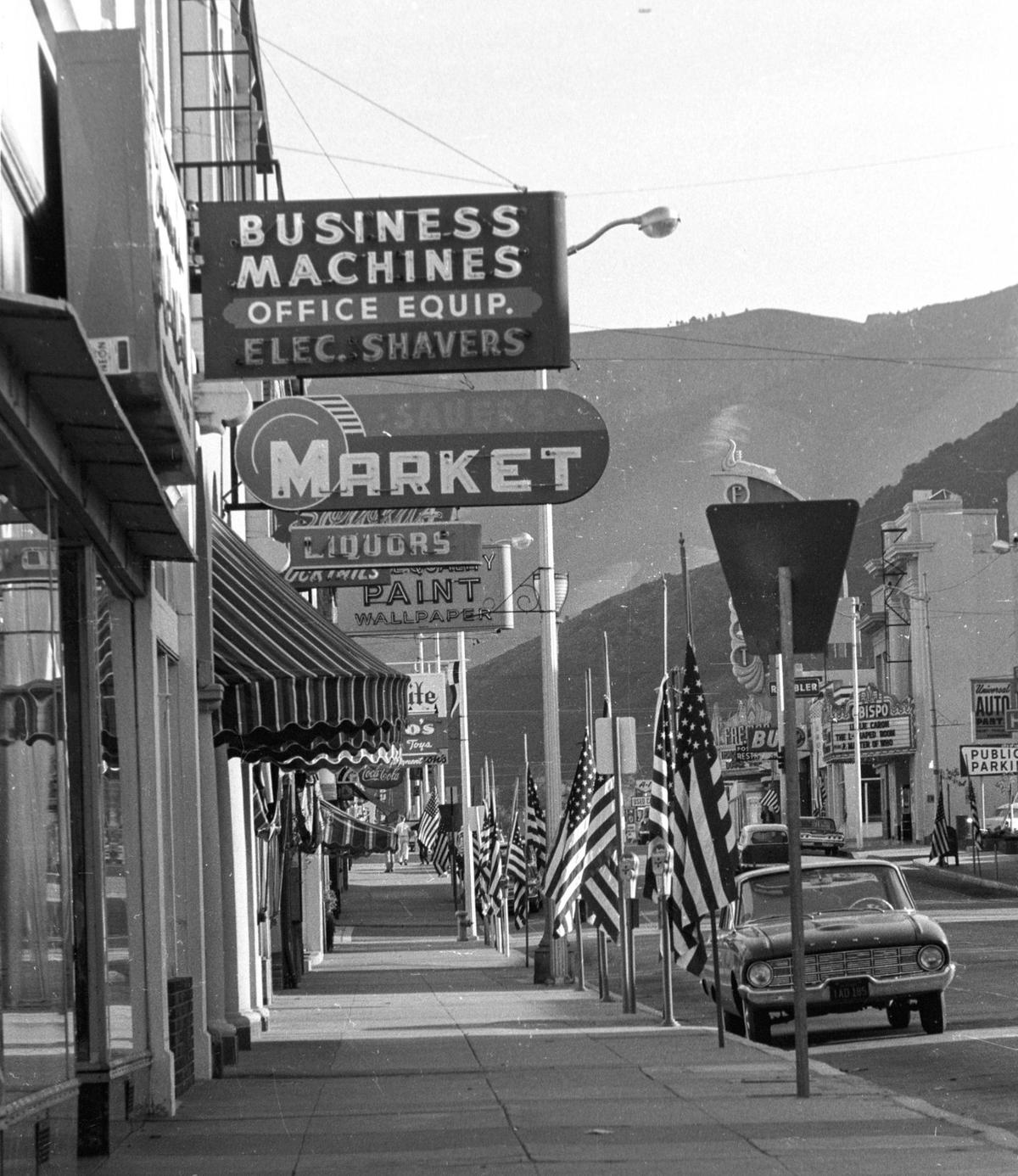 Flags line Monterey Street in San Luis Obispo in the wake of the assassination of President John F. Kennedy on Nov. 22, 1963. There were no trees and awnings and neon signs fronted most businesses.