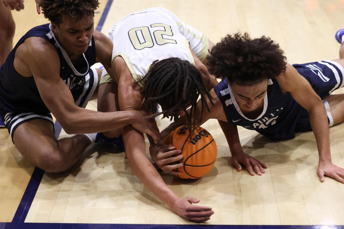 Gavin Marin comes up with the ball in a critical late-game scramble for Arroyo Grande. Also on the floor Caleb Clark, at left, and Jayden Nozil, center. Arroyo Grande beat Mission Prep 50-44 in a boys basketball game on Jan. 12, 2024.