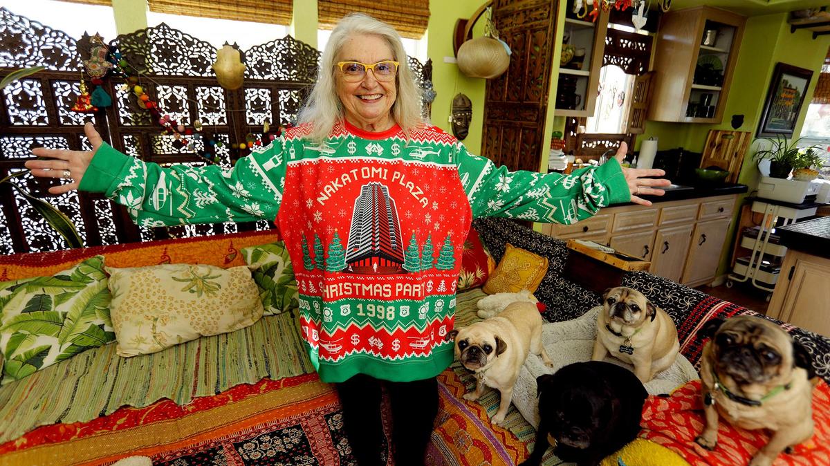 Sherry Scott, a Grover Beach “Die Hard” fan, poses in her Nakatomi Plaza Christmas sweater with her four rescue pugs. “I just love the action,” she says.