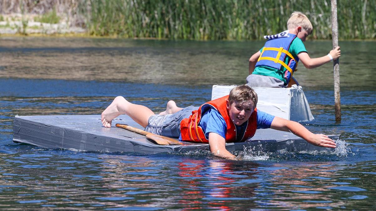 Carson Savino, 11, abandons his paddle and uses his hands to propel himself to first place in the kids division of the cardboard boat race at the 2022 Atascadero Lake Fest. The race included a variety of designs, and Savino’s rectangle was more barge than boat.