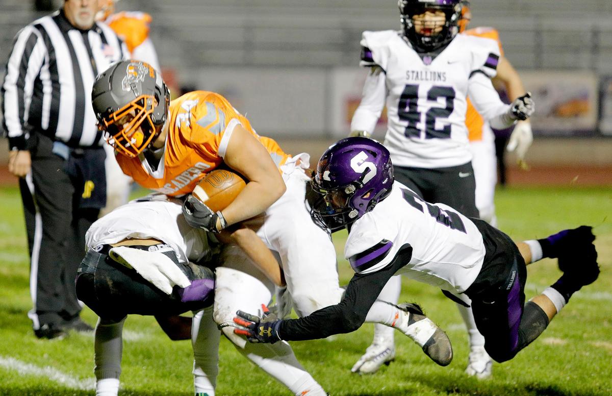 Greyhound ball carrier Trey Cooks (34) is tackled by the Madera South defense. Atascadero beat Madera South 39-8 in the second round of the CIF Central Section Division 5 football playoffs on Nov. 10, 2022.