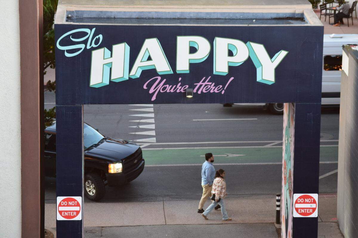 People walk past a mural at the Marsh Street parking garage in downtown San Luis Obispo in October 2025.