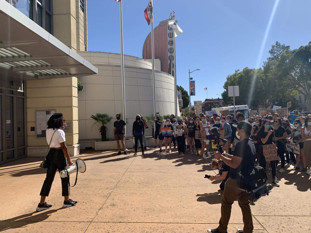 Tianna Arata, one of several protest organizers, addresses a crowd of about 150 people outside the San Luis Obispo County Government Center June 8, 2020, to demand a reallocation of law enforcement funding towards social services.