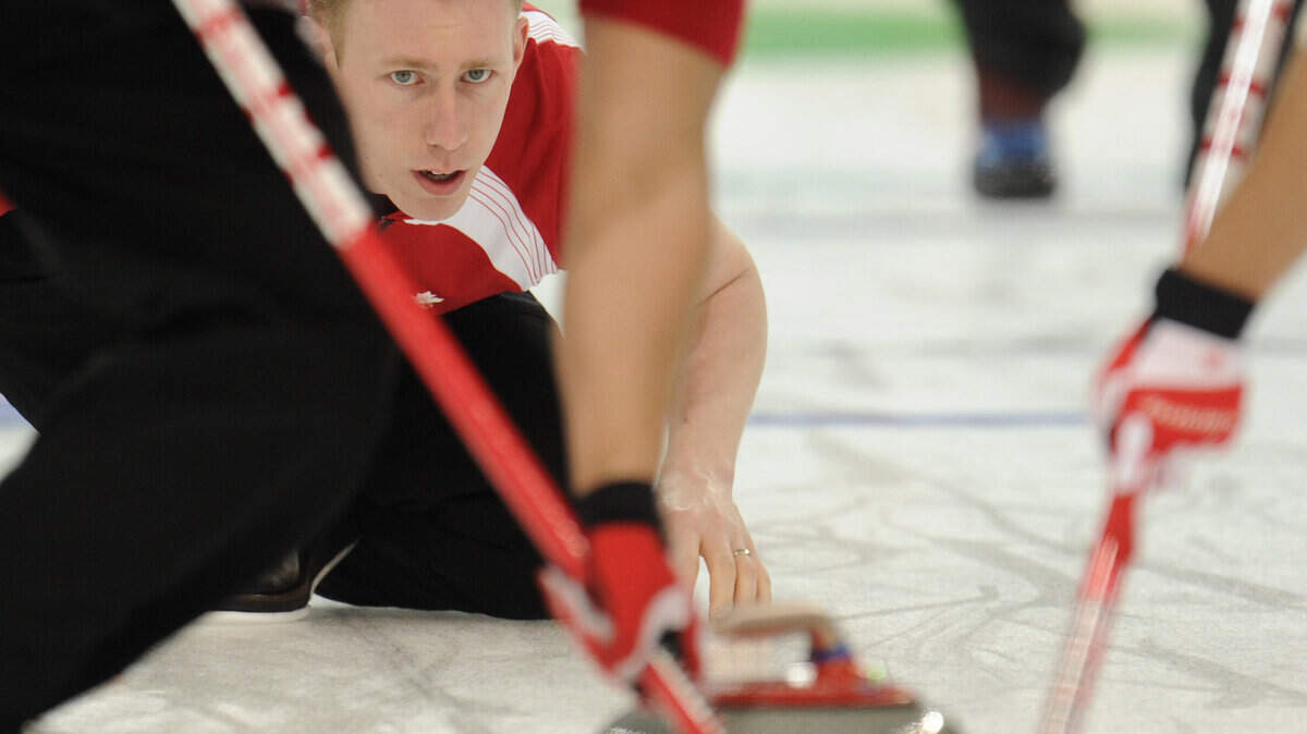 Canadian Marc Kennedy (center) keeps an eye on his rock, swept by Ben Herbert (left) and John Morris during curling action against the USA.  (Gerry Kahrmann / Canwest News Service / MCT)