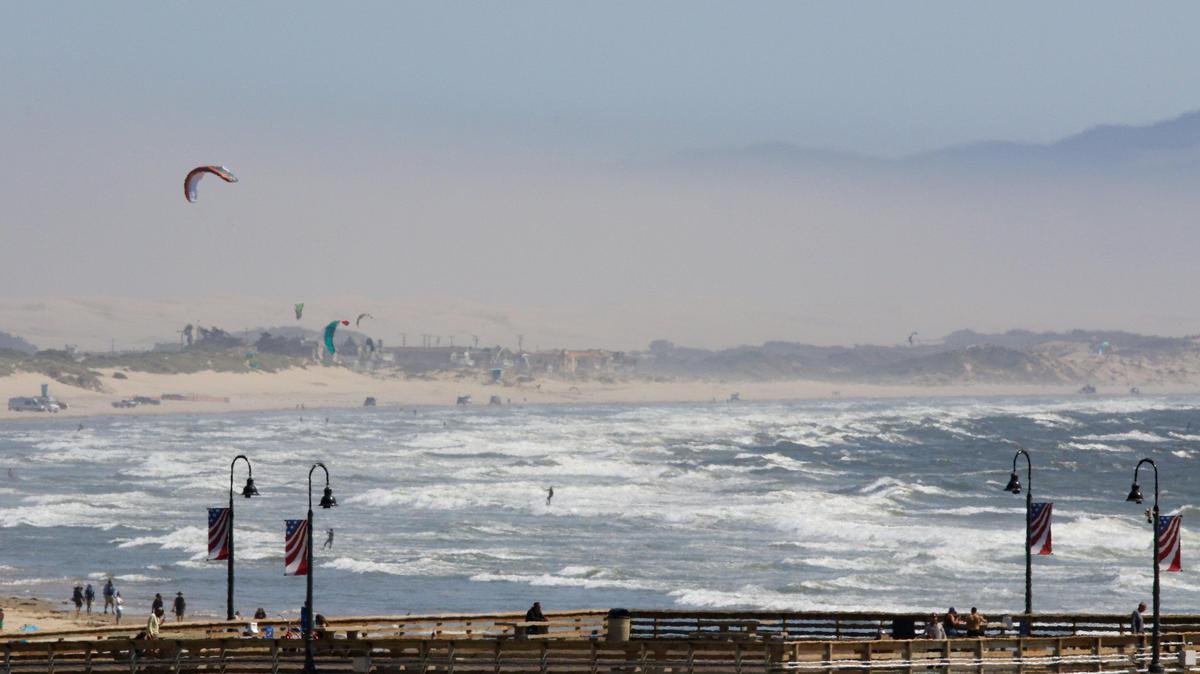 Strong winds blow a plume of dust from the Oceano Dunes toward the Nipomo Mesa in August 2019 in a view from the Pismo Beach Pier. On that day, air quality levels on the Nipomo Mesa moved into unhealthy levels at 145 PM10 as compared to 30 in San Luis Obispo or 18 in Atascadero.