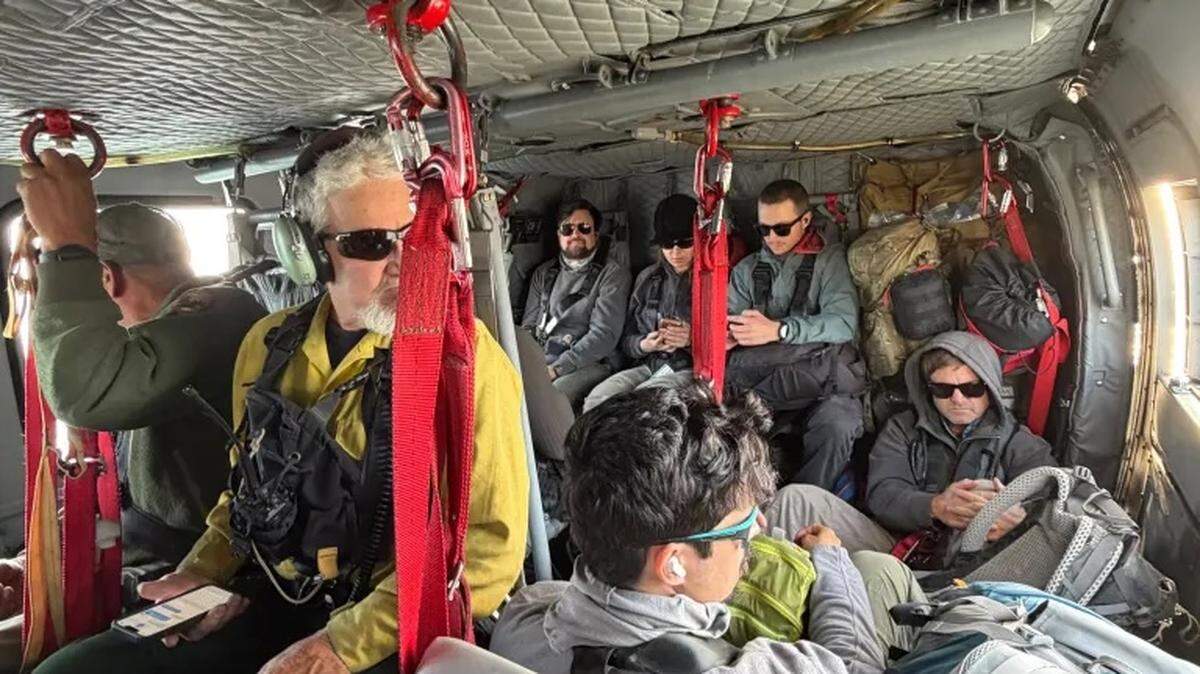 National Park Service employees sit inside Santa Barbara County Copter 964 for their evacuation from Santa Rosa Island due to a fire, on Sunday, May 17, 2026.